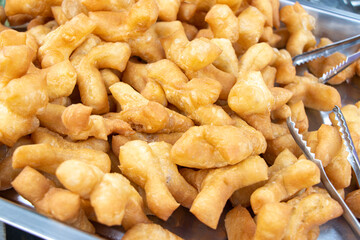 The offer of a deep-fried dough stick at Thai market, close up.
