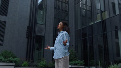 Stressed manager meditating at office building outdoors. Piece of mind concept.