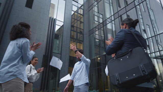 Confident leader celebrating success with team outdoor. Professional recognition