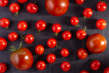 Heap of tomatoes at black slate background table