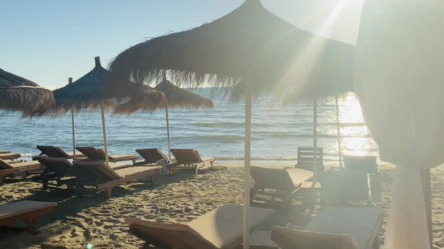 Sunbeds during golden hour sun flare sandy beach albania durres 