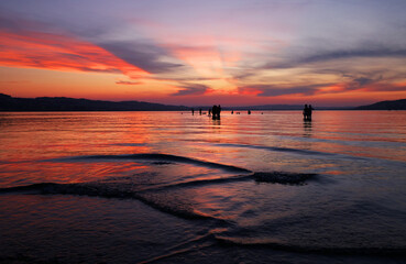 Naklejka premium Tourists at Sempach Lake in Switzerland, Europe. Sunset light.