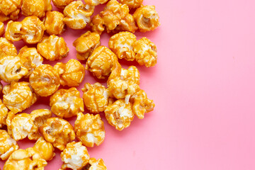 Honey caramel popcorn on pink background.