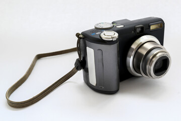 compact digital camera in black with a gray zoom lens on a white background close-up