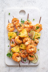 kebab skewers of barbecued shrimp with a pineapple