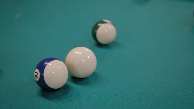 Slow motion: hitting colorful pool balls on teal billiard table - close up. Sport, game, competition, hobby and leisure time concept