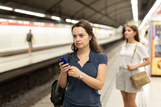 Young woman wth phone on subway station. High quality photo