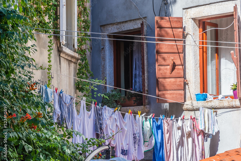 Wall mural old house with clothes line at the balcony before windows