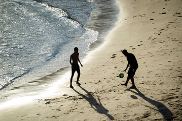  Two young men playing beach soccer at beach