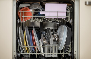 open dishwasher with clean dishes, utensils and pots