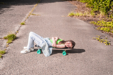 young girl with her skateboard on a sunny day in the park