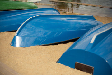 Blue boats lie on sand. Boat station on beach.