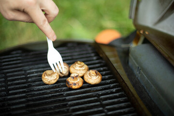 Mushrooms are grilled. Picnic details. Food on steel grate.