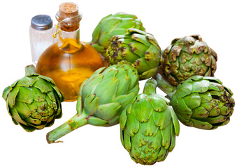 Fototapeta premium Organic green artichokes, bottle with olive oil and salt, food preparation. Isolated over white background