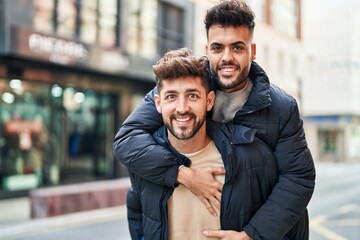 Young couple smiling confident holding boyfriend on back at street