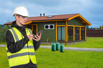 Air conditioner specialist. Refueling air conditioner with tablet. Man in protective helmet next to...