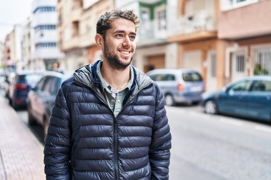 Young man smiling confident looking to the side at street