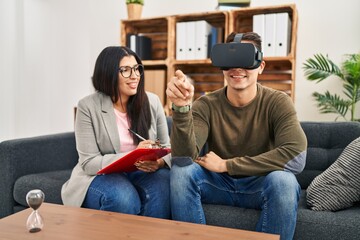 Man and woman having virtual reality psychology session at clinic