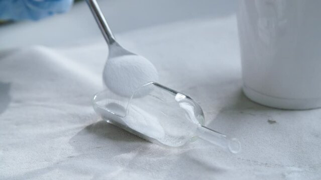 White poweder into scoop for scientific experiment. Close up.