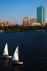 Two sailboats ply the Charles River in tandem as part of the Community Boating in Boston