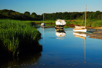 Boats are stranded on a sand bar at low tide in Brewster Creek Park, on Cape Cod