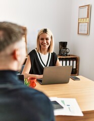 Two business workers smiling happy working using laptop at the office.