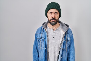 Young hispanic man with tattoos wearing wool cap depressed and worry for distress, crying angry and afraid. sad expression.