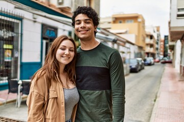 Young interracial couple smiling happy and hugging standing at the city.