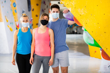 Portrait of women and guy in protective mask in a climbing gym