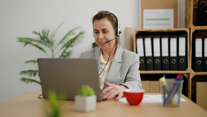 Middle age hispanic woman call center agent having video call at office