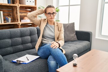 Young woman working at consultation office confuse and wondering about question. uncertain with...