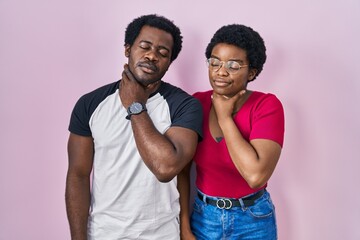 Young african american couple standing over pink background touching painful neck, sore throat for flu, clod and infection