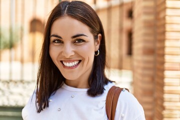 Young hispanic girl smiling happy standing at the city.