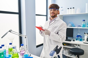 Young arab man scientist using touchpad working at laboratory