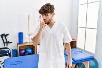 Obraz premium Young arab man working at pain recovery clinic feeling unwell and coughing as symptom for cold or bronchitis. health care concept.