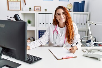 Obraz na płótnie Canvas Young redhead woman wearing doctor uniform working at hospital