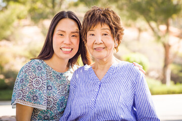 Fototapeta premium Outdoor portrait of a happy Chinese mother and daughter