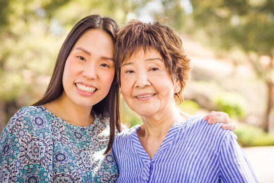 Outdoor portrait of a happy Chinese mother and daughter