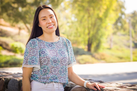 Outdoor portrait of a happy Chinese young adult woman.