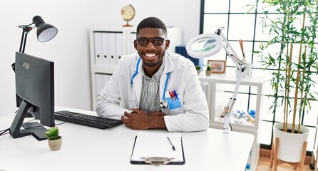 Young african american man wearing doctor uniform working at clinic