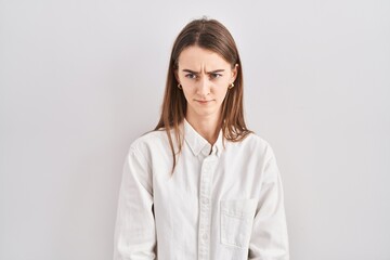 Young caucasian woman standing over isolated background skeptic and nervous, frowning upset because...