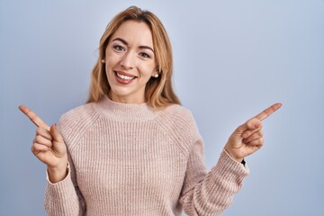 Hispanic woman standing over blue background smiling confident pointing with fingers to different directions. copy space for advertisement