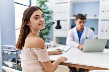 Fototapeta premium Man and woman wearing doctor uniform having medical consultation at clinic