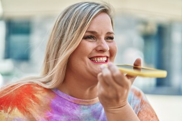 Young woman smiling confident talking on the smartphone at street