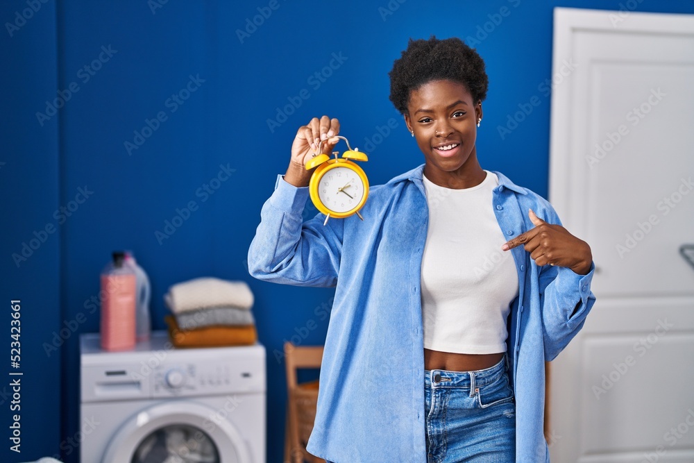 Wall mural African american woman waiting for laundry pointing finger to one self smiling happy and proud