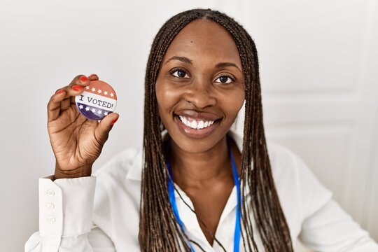 Young african american politic party worker holding badge at electoral college.