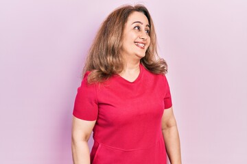 Middle age caucasian woman wearing casual clothes looking away to side with smile on face, natural expression. laughing confident.