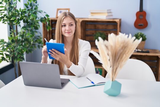 Young caucasian woman using laptop and touchpad styding at home