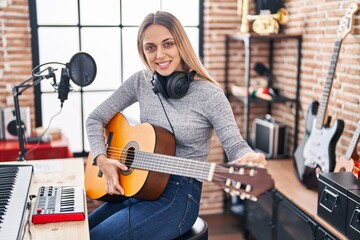 Fototapeta na wymiar Young woman artist singing song playing classical guitar at music studio