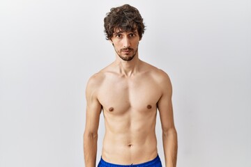 Fototapeta premium Young hispanic man standing shirtless over isolated, background depressed and worry for distress, crying angry and afraid. sad expression.